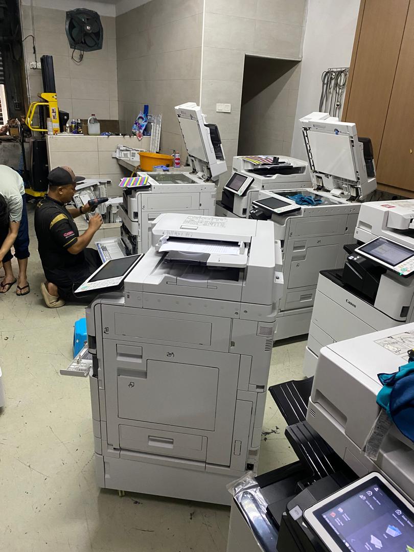 Service team working on several multifunction copiers in the workshop