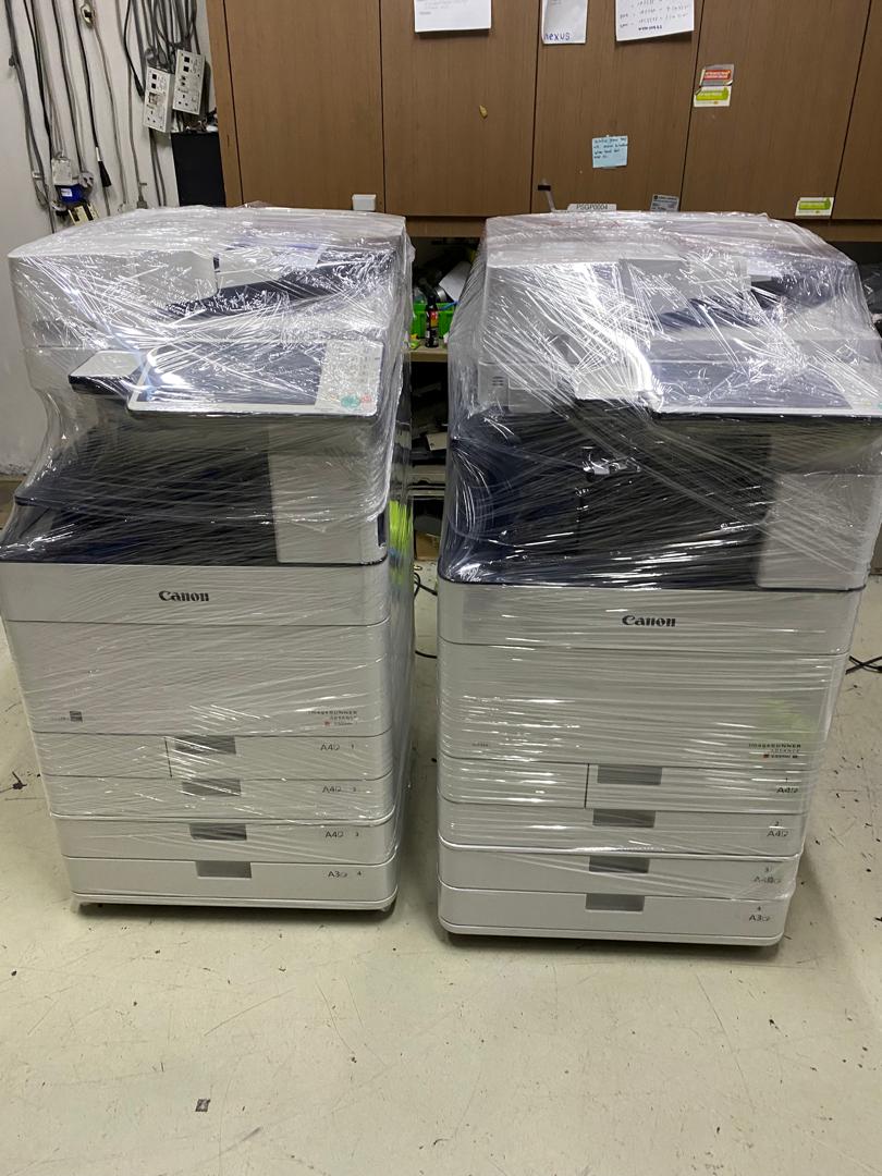 Two wrapped Canon multifunction printers ready for deployment